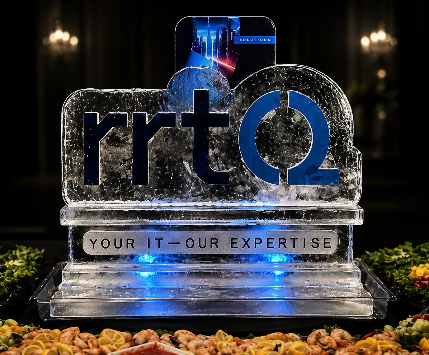 Large rrtQ ice sculpture with carved lettering and a blue-lit base beside a seafood display.